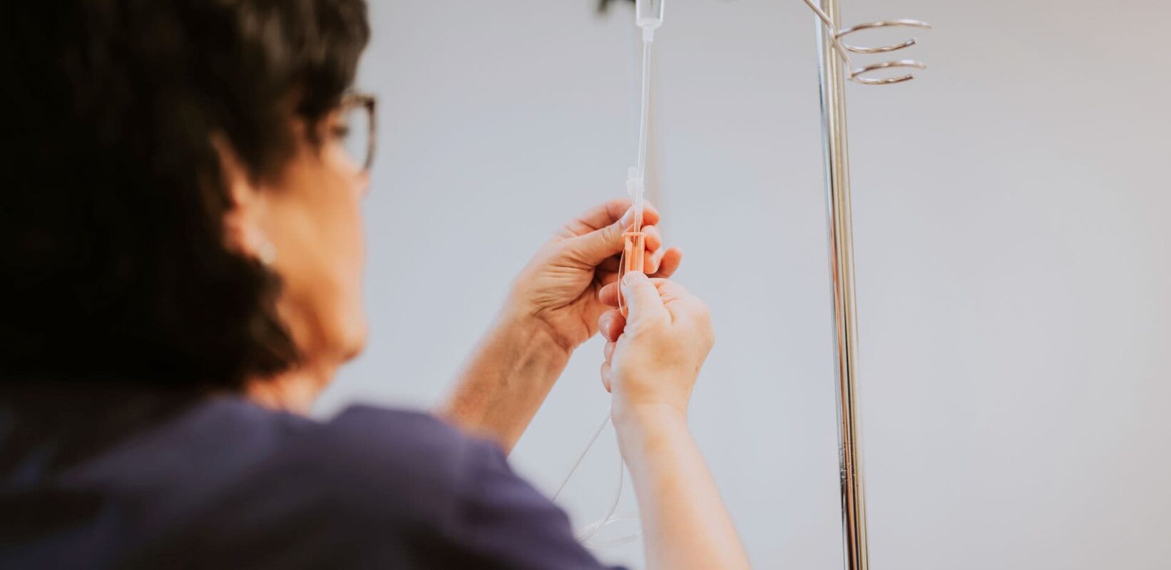 Eine MFA bereitet die Infusion für einen Patienten vor.
